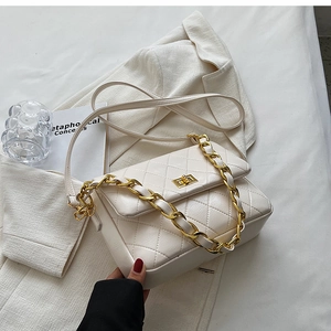 Detail of white quilted faux leather bag with gold chain strap and metal buckle