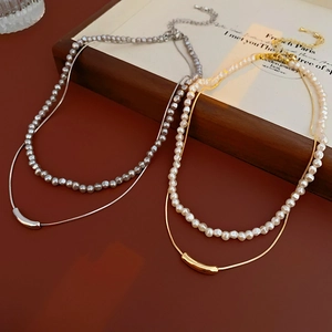 Detail of layered gold and silver pearl necklaces with adjustable lobster clasp closure