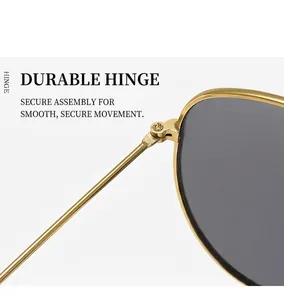 Macro view of a sturdy gold metal hinge and high-quality grey lenses on sunglasses