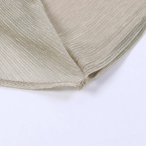 Détail du tissu plissé métallique champagne doré avec finitions de couture d'ourlet