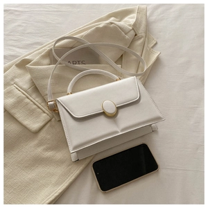 Vue détaillée du sac à main structuré crème avec boucle dorée et poignée supérieure