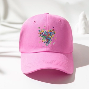 Dettaglio del cappellino in cotone rosa con stampa a cuore composta da farfalle colorate