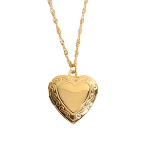 Golden heart locket necklace with floral engraving on a twisted stainless steel chain
