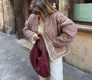 Detail of floral quilted cotton jacket styled with a burgundy woven leather tote bag