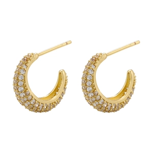Detailed view of gold C-shaped earrings with pave-set zircon stones and glossy finish