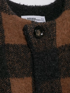 Detail of plaid knit cardigan neckline with marble textured button and warm bouclé texture