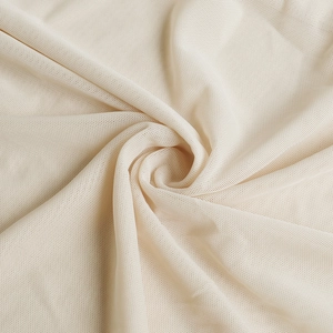 Close-up detail of soft beige mesh fabric with intricate knit texture and elegant pleats