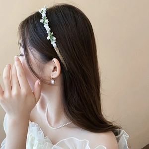 Détail d'un serre-tête floral en perles avec boucles d'oreilles et collier assortis