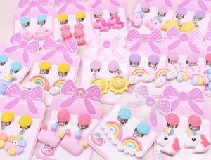 Detailed view of kids clip-on earrings with unicorn, rainbow and cloud resin patterns