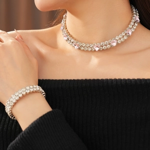 Vue détaillée du collier double et du bracelet avec cœurs roses et cristaux brillants