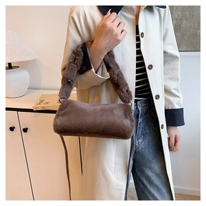 Detail of a brown faux fur handbag with a thick plush shoulder strap and metal rings