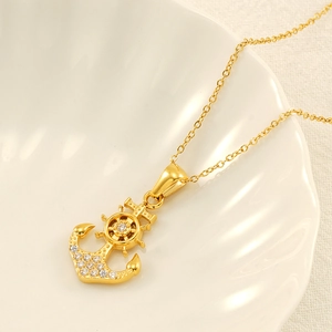 Collier avec pendentif ancre et gouvernail dorés avec zircons dans un coquillage