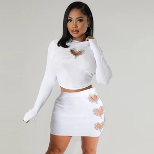 Detail of white ribbed knit two-piece set featuring rhinestone heart cutout design