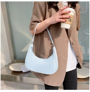 Close-up of light blue nylon hobo bag featuring a crescent shape and silver zipper