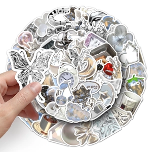 Detailed macro view of liquid metal Y2K stickers with silver butterfly and cherry designs