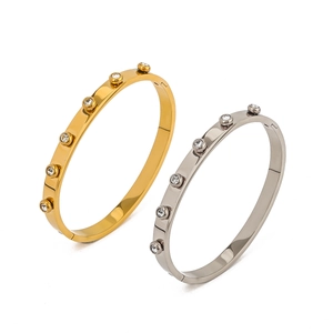 Detail of 18K gold and silver stainless steel bangles with sparkling round zirconia stones