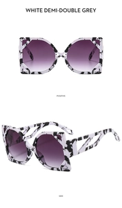 Detail of white demi-double grey marble cat-eye sunglasses with purple gradient lenses