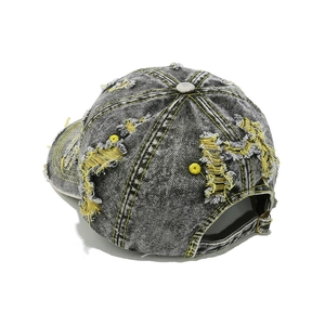 Détail d'une casquette en coton délavé avec coutures jaunes et déchirures de style rétro