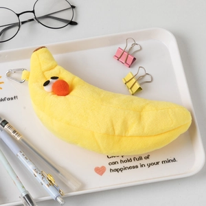 Macro view of cute plush banana pouch with silver metal clip and embroidered expression