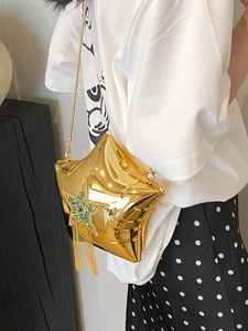 Detail of star-shaped gold bag with rhinestone fringes and metallic chain strap