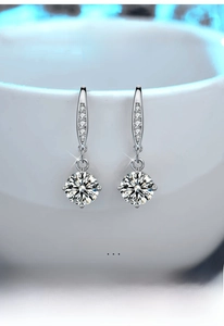 Macro detail of S925 sterling silver four-prong moissanite drop earrings with diamonds