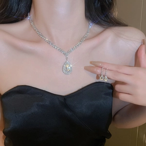 Detailed close-up of water drop zircon jewelry set worn by a model in silver finish