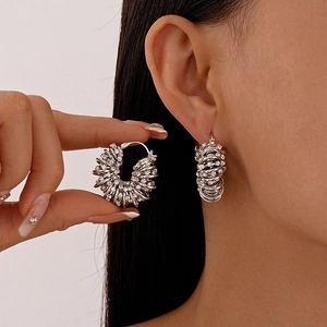 Boucles d'oreilles géométriques en U argentées avec strass sur un mannequin