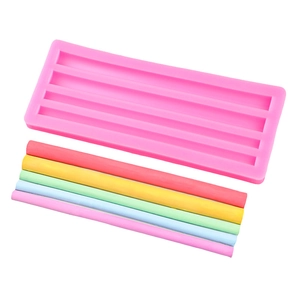 Pink silicone mold with five colorful DIY wax bars on white background