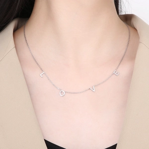 Détail du collier argenté avec lettres LOVE sur une chaîne en acier inoxydable
