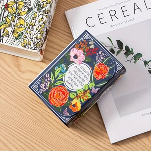 Macro view of book-shaped ceramic vase with floral prints and inspirational English quote