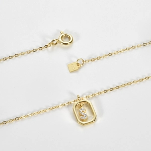 Detailed close-up of S925 sterling silver S-letter pendant with hexagon frame and hallmarked tag
