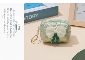 Detail of light green quilted bow coin purse with gold keychain and ribbon accent