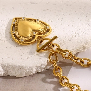 Gros plan du pendentif cœur en or 18K avec texture radiante et fermoir OT sur chaîne