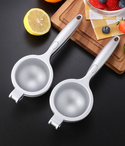 Dual silver zinc alloy lemon squeezers on dark background with fresh fruit and board