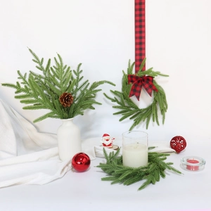 Detail of Norfolk pine wreath with red plaid ribbon and festive candle decoration