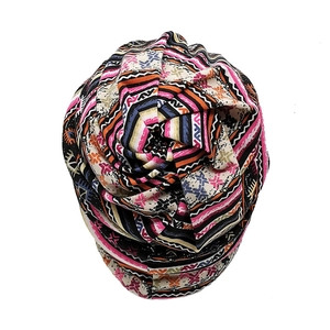 Close-up of bohemian turban hat featuring a colorful geometric print and top knot detail