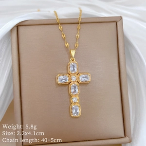 Macro view of gold cross pendant with cubic zirconia stones and product dimensions