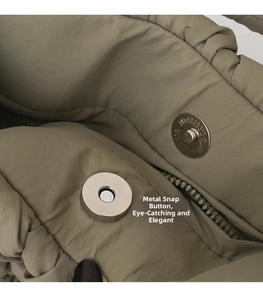 Close-up of magnetic metal buckle and quilted fabric on khaki padded shoulder bag