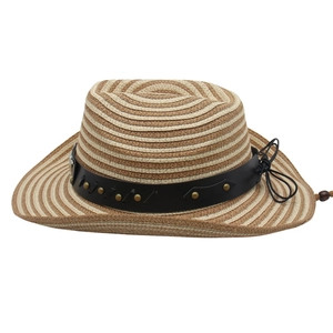 Détail d'un chapeau de cowboy en paille tressée avec bande en cuir et clous dorés