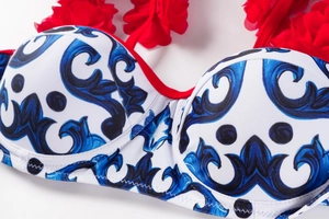 Close-up of Mediterranean blue floral swimsuit top with a 3D red fabric flower detail