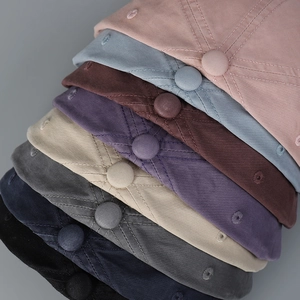 Detail view of washed cotton baseball caps in eight various colors with letter embroidery