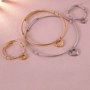 Gold and silver heart pendant bangles with elegant twisted wire design and metal beads
