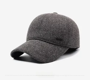 Detail view of dark grey wool blend baseball cap with side metal logo and ear protection