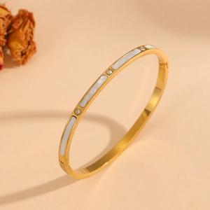 Detail of 18k gold plated flower heart bangle with white shell inlay and crystals