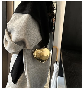 Detail showing metallic gold heart-shaped crossbody bag with Fashion & Bags engraving