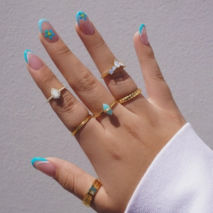 Detailed close-up of various gold-plated S925 silver rings with teardrop opals and zircons