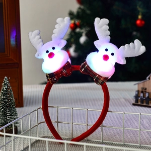 Glow reindeer headband with white antlers and plaid bows in a festive holiday setting