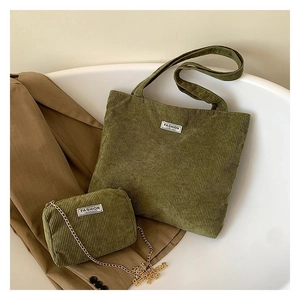 Detail view of army green corduroy tote and chain crossbody bag set on brown blazer