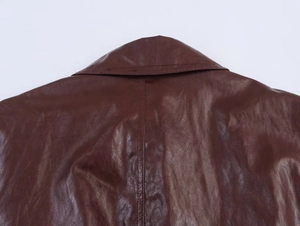 Detail of deep brown faux leather jacket collar showing fine stitching and smooth texture