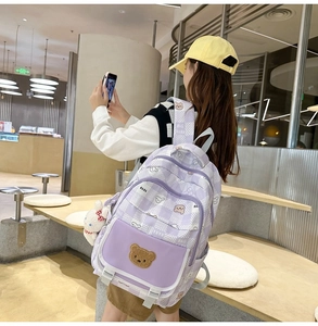 Detail view of purple bear backpack with plush bunny charm and adjustable white straps